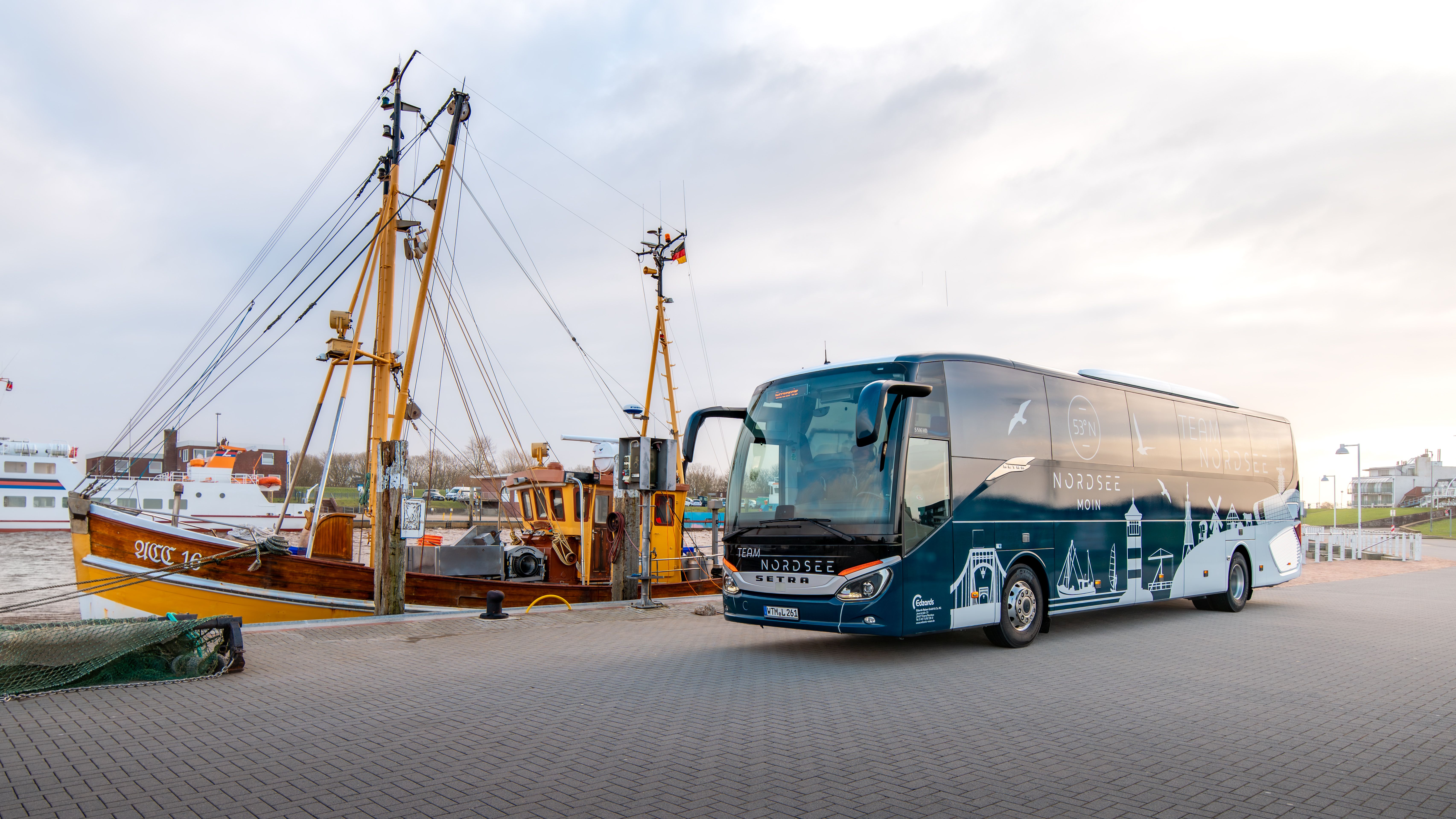 Bus der Nordsee Niedersachsen vor einem Kutter