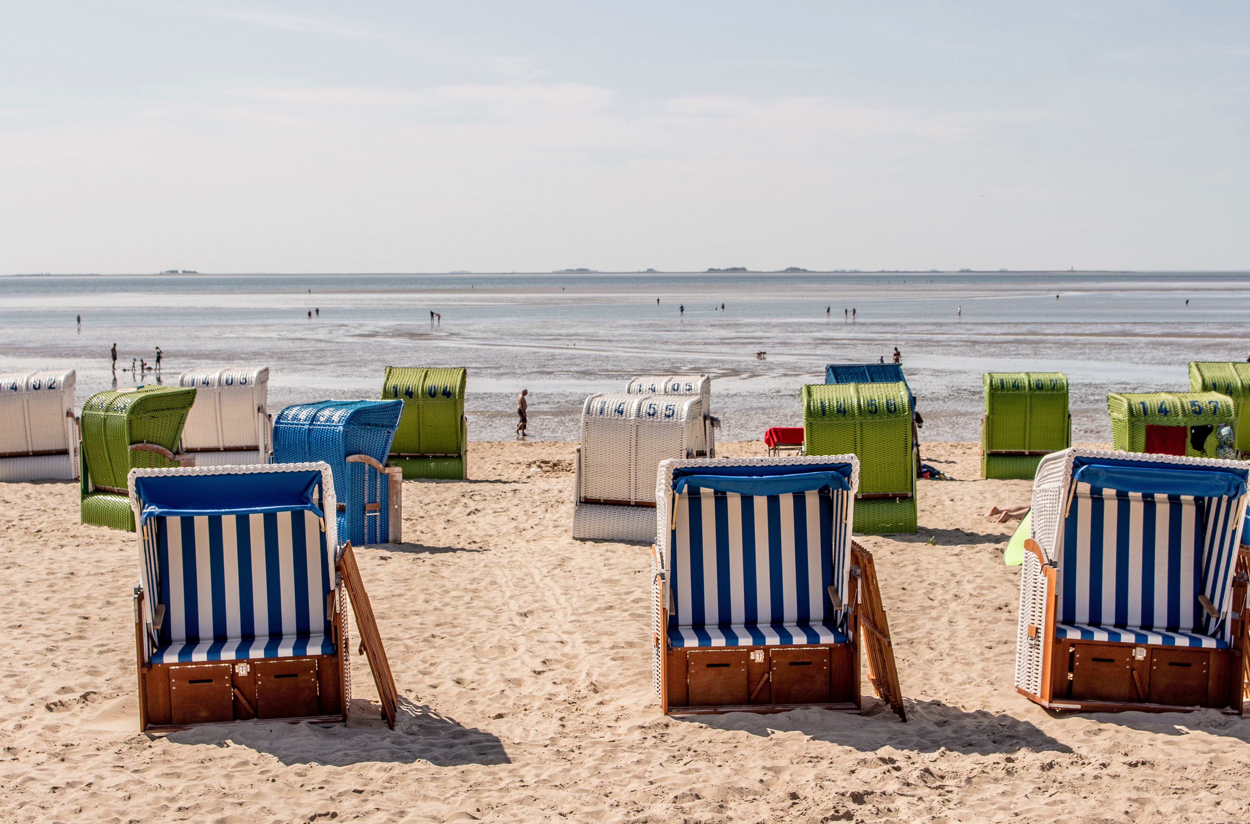 Viele Strandkörbe stehen am Sandstrand von Wyk, im Hintergrund ist das Meer zu sehen