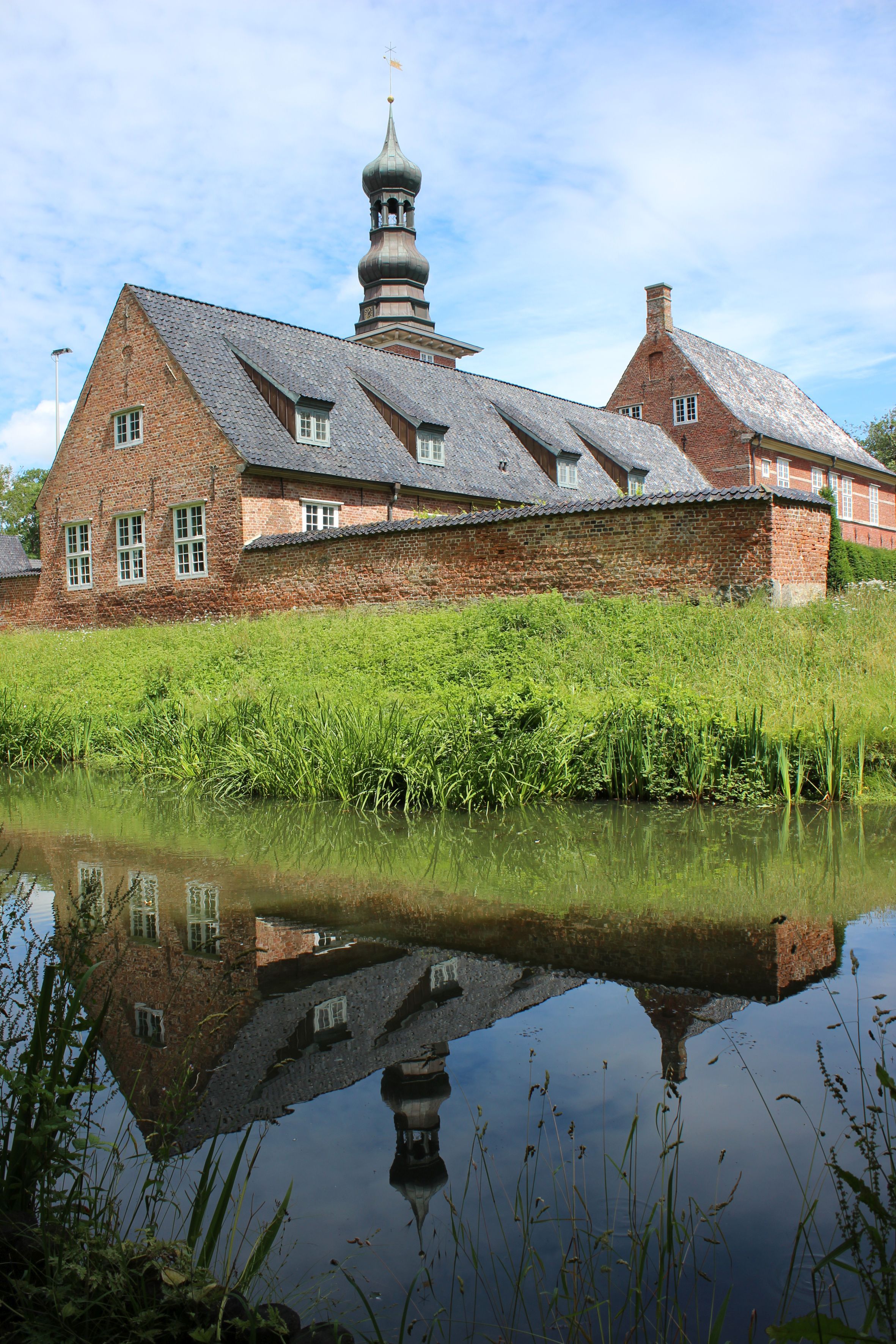 Blick auf das Schloss vor Husum, das sich im Wasser spiegelt