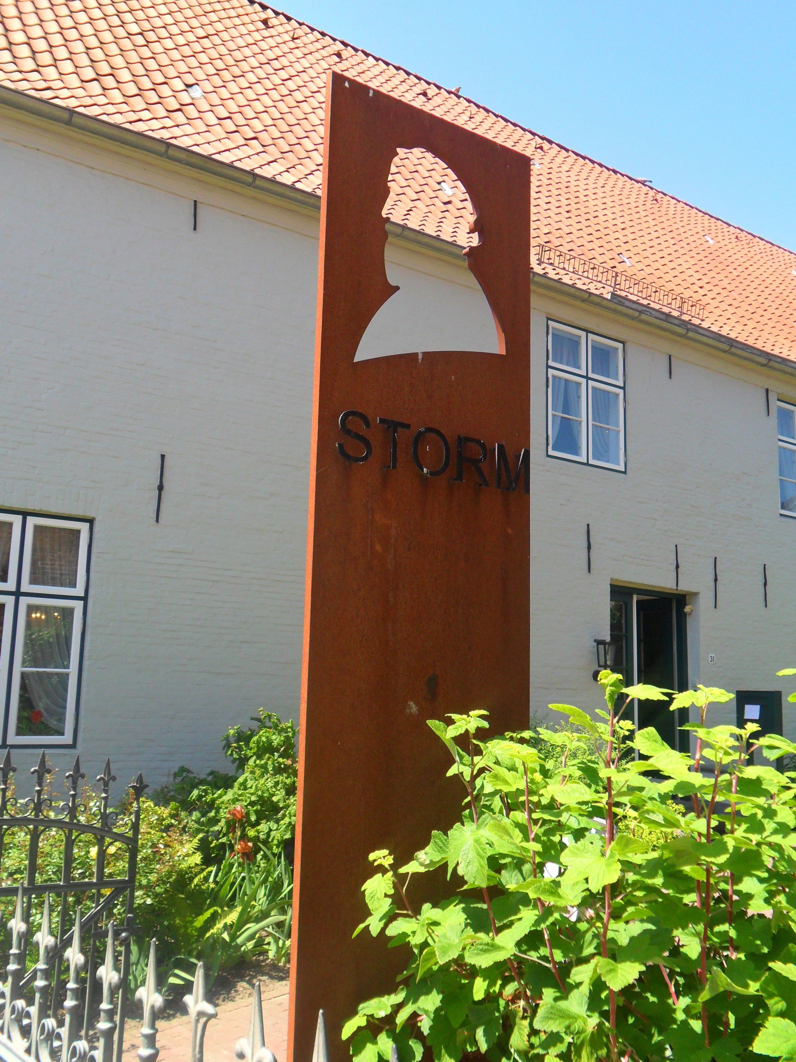 Eine Silhoutte von Theodor Storms Gesicht steht vor seinem Haus in Husum