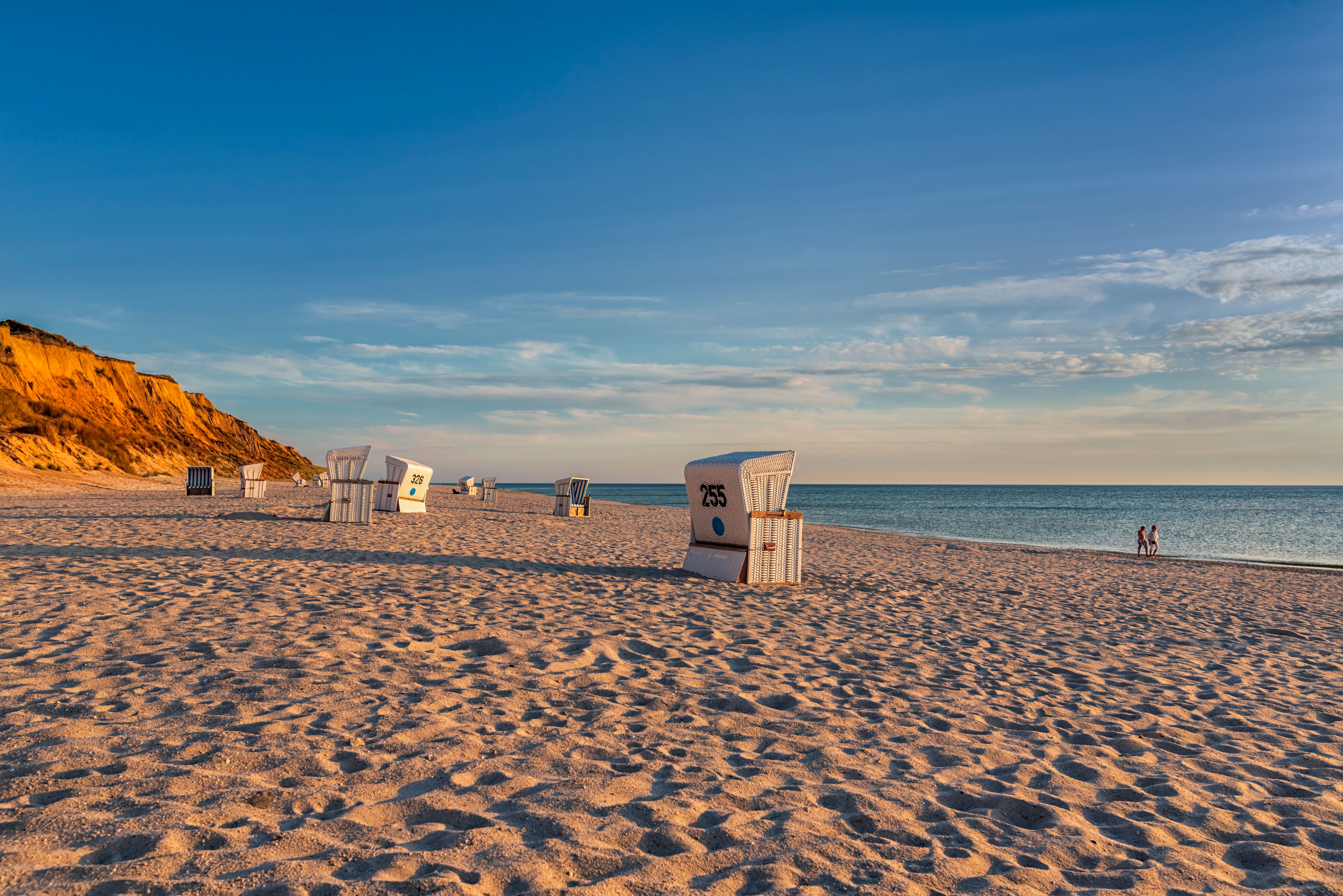 Strandkörbe stehen auf dem Strand vor dem Roten Kliff