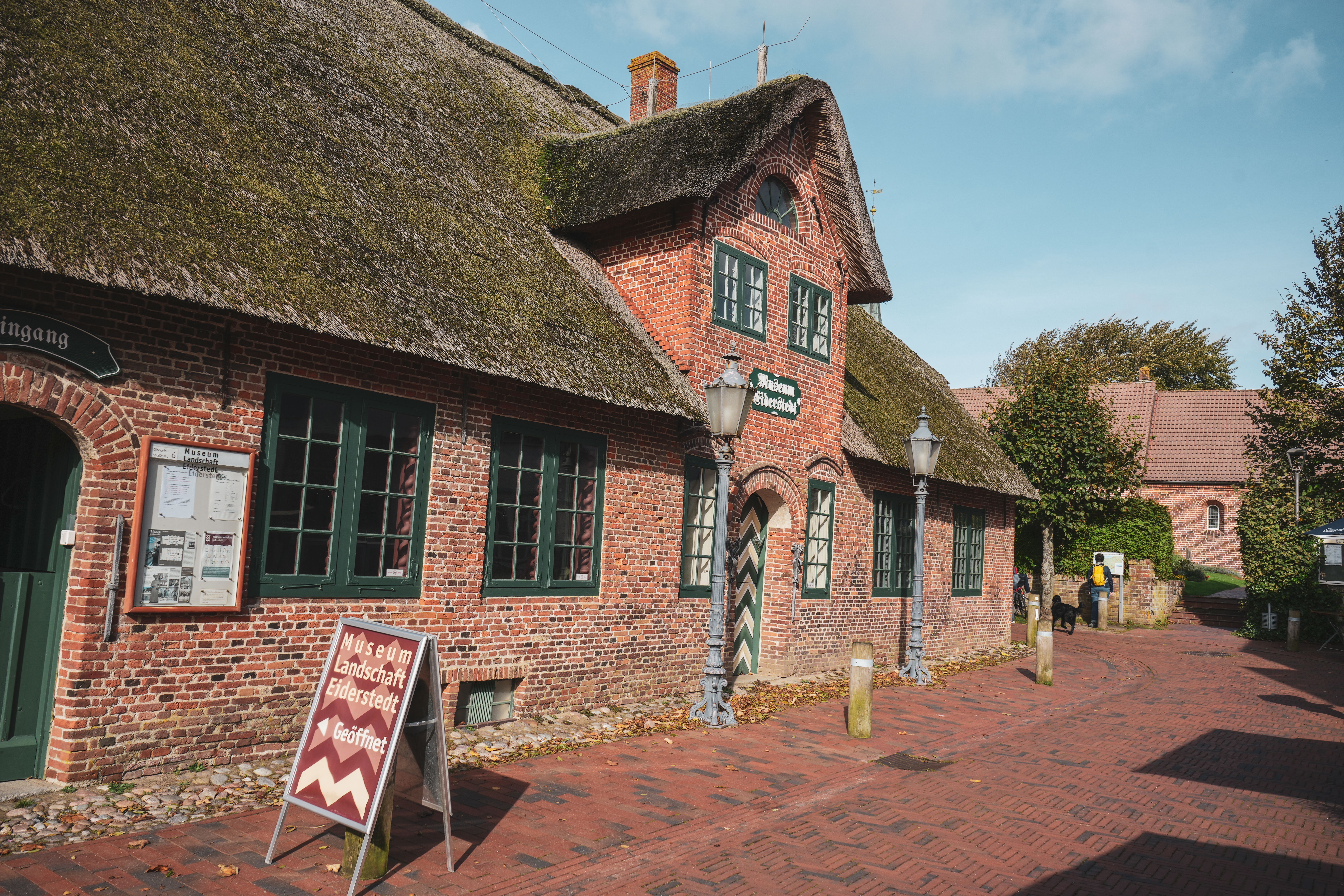 Außenansicht des roten Backsteinhauses mit Reetdach. das das Museum der Landschaft Eiderstedt beinhaltet