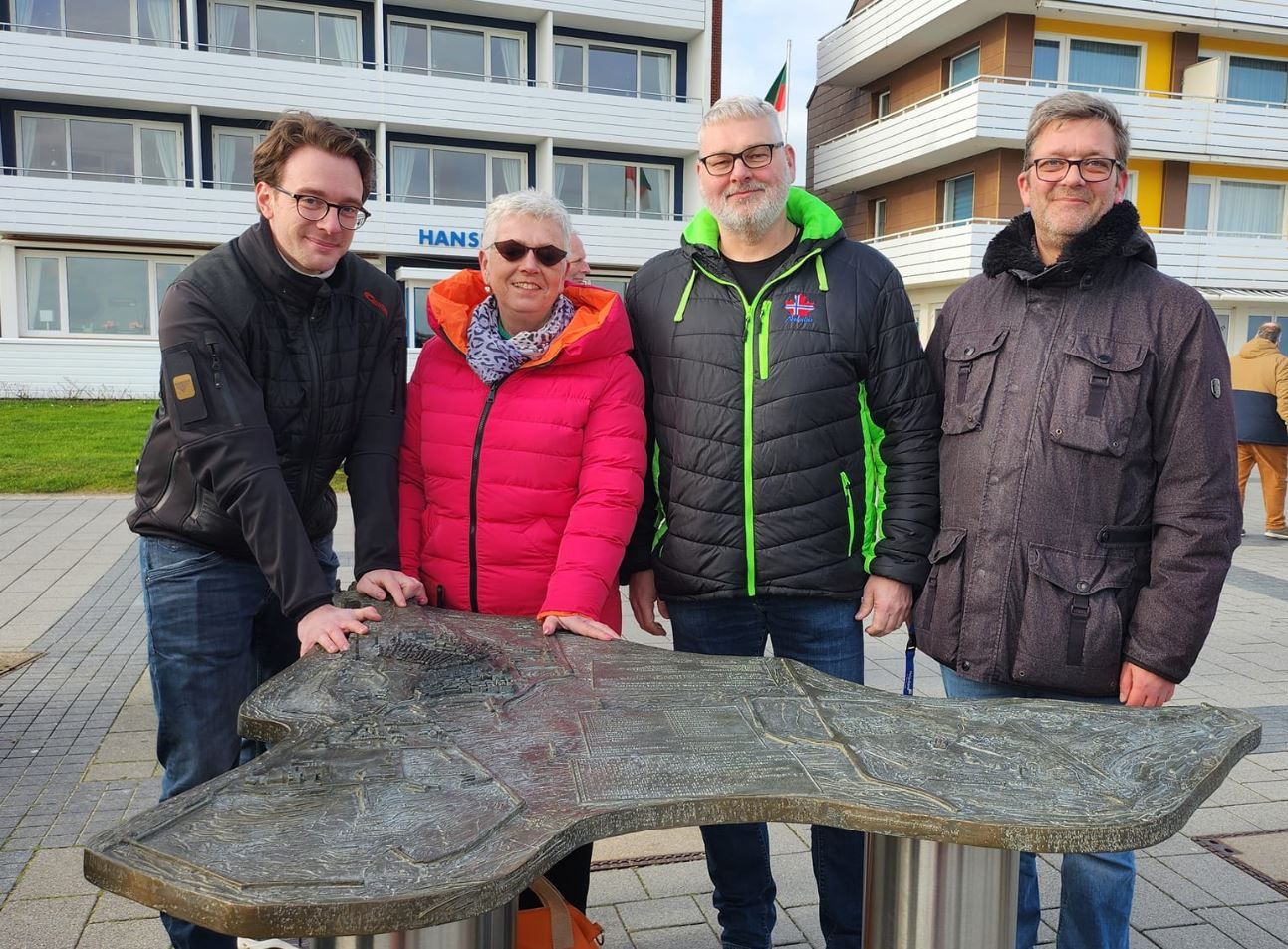 Mitarbeiter des Projekts Blindentastmodell posieren vor dem grauen Modell auf Helgoland