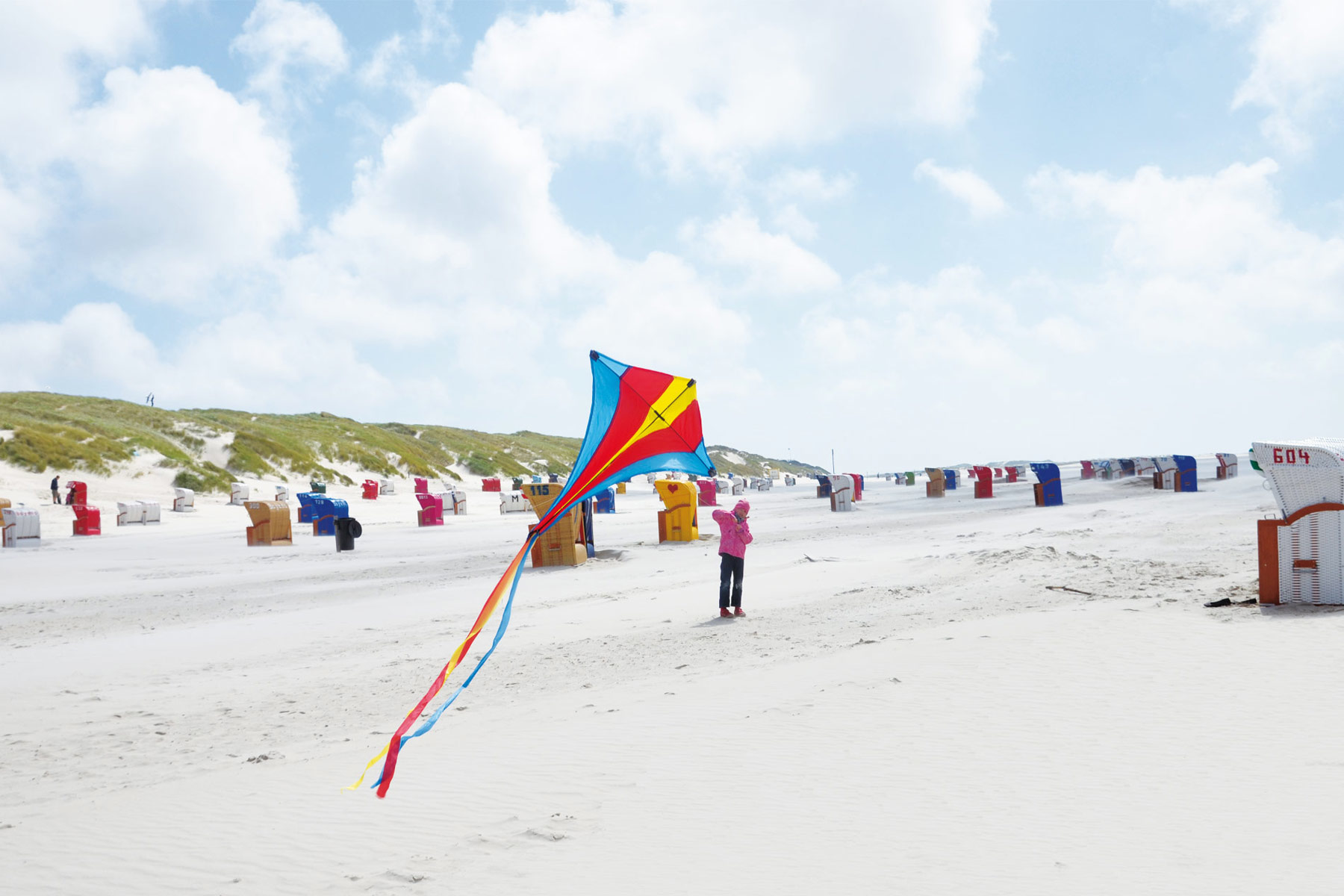 Ein Kind lässt am Norddorfer Sandstrand einen Drachen steigen