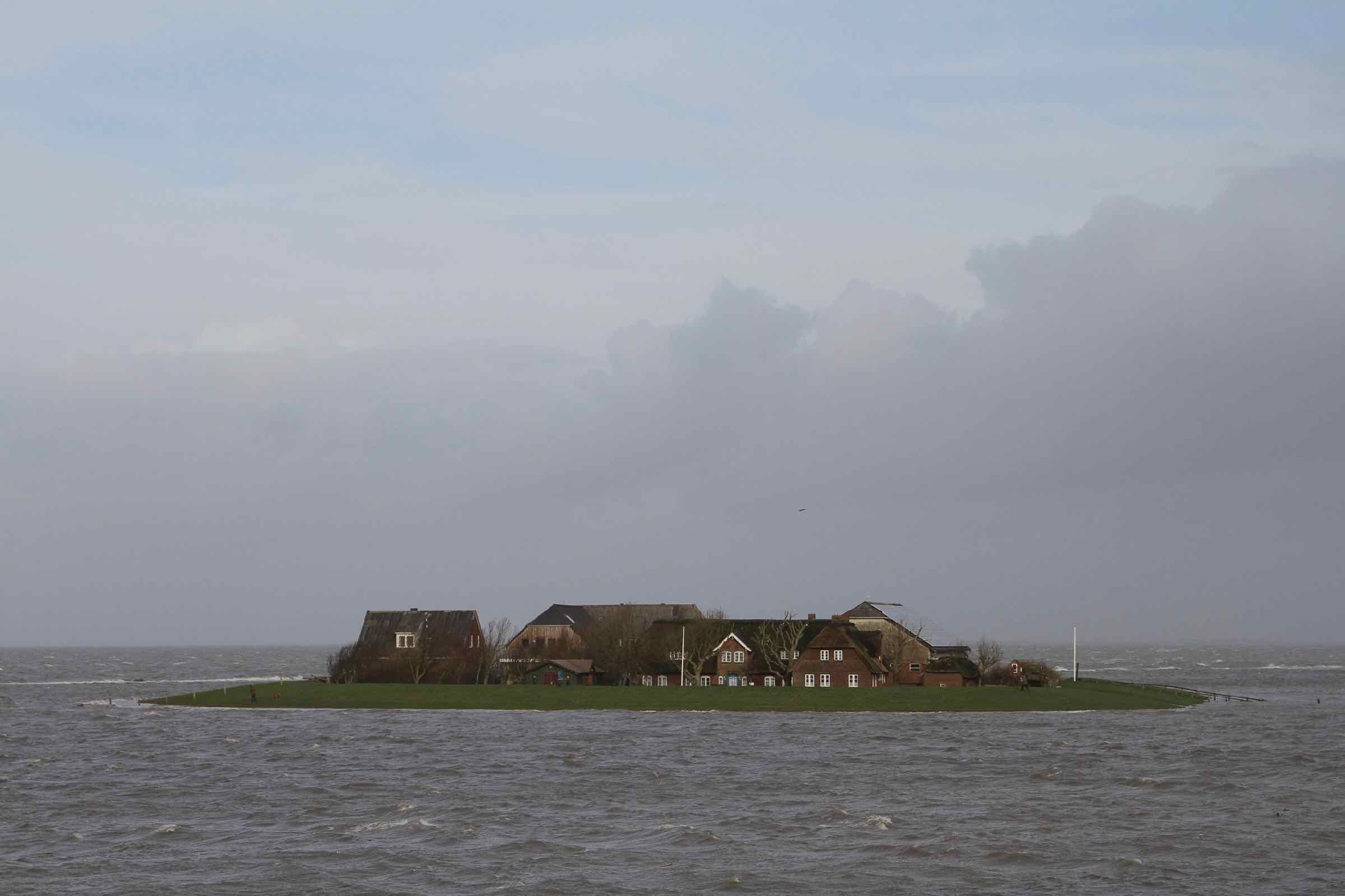 Um ihre Häuser bei Landunter vor dem Wasser der Nordsee zu schützen, wohnen die Halliglüüd auf Warften.